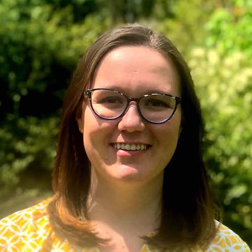 woman with medium long brown hair wearing glasses