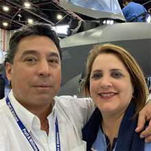 a man and woman standing in front of a jet