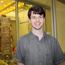 man in front of the inner components of a space telescope
